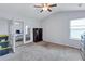 Bright bedroom with neutral carpet, a ceiling fan, and mirrored closet doors at 109 Jodi Pl, Locust Grove, GA 30248