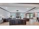 Expansive living room featuring wood floors, modern lighting, a fireplace, and access to a well-appointed kitchen space at 109 Jodi Pl, Locust Grove, GA 30248