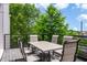 Outdoor dining set on a wooden deck with a metal railing, surrounded by lush trees at 167 Sampson Ne St, Atlanta, GA 30312