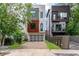 Modern, three-story home featuring a brick driveway, a two-car garage, and a mix of white, wood, and gray exterior accents at 167 Sampson Ne St, Atlanta, GA 30312
