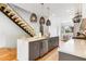 Modern kitchen with quartz countertops, stainless steel appliances, island seating, and open staircase with glass railing at 167 Sampson Ne St, Atlanta, GA 30312