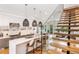 Bright, modern kitchen with a white island, pendant lighting, stainless steel appliances, and open staircase with glass railing at 167 Sampson Ne St, Atlanta, GA 30312