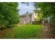View of the home's backyard, featuring a two-story home with a well-maintained lawn and trees at 2732 Dahlonega Trl, Austell, GA 30106