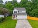 Charming two-story home with a well-maintained lawn and a two-car garage nestled among green trees at 2732 Dahlonega Trl, Austell, GA 30106