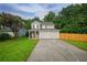 Charming two-story home with a well-maintained lawn and a two-car garage nestled among green trees at 2732 Dahlonega Trl, Austell, GA 30106