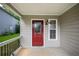Cozy front porch featuring a red door and a window for natural light, perfect for enjoying the outdoors at 2732 Dahlonega Trl, Austell, GA 30106