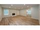 Open-concept living room with hardwood floors, a fireplace, and ample natural light, perfect for gatherings at 2732 Dahlonega Trl, Austell, GA 30106