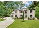 Elegant modern home with a painted brick facade, manicured lawn, and a circular driveway at 4125 Ashwoody Ne Trl, Brookhaven, GA 30319