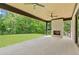 Outdoor patio featuring a brick fireplace, ceiling fans, and a view of the spacious backyard at 4125 Ashwoody Ne Trl, Brookhaven, GA 30319