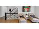Hallway featuring a staircase with black railing and two elegant chairs near colorful artwork at 4222 Rickenbacker Ne Dr # 9, Atlanta, GA 30342