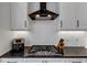 Modern kitchen featuring white herringbone backsplash, black countertops, and sleek stainless steel stove top at 4222 Rickenbacker Ne Dr # 9, Atlanta, GA 30342