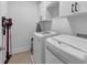 Well-lit laundry room with modern washer, dryer, upper cabinets and a wall-mounted vacuum at 4222 Rickenbacker Ne Dr # 9, Atlanta, GA 30342