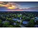 Scenic aerial view of a community featuring lush greenery, tennis courts, and beautiful homes at sunset at 4620 Springdale Ct, Cumming, GA 30041