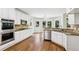 Bright kitchen with white cabinets, stainless steel appliances, hardwood floors and granite countertops at 4620 Springdale Ct, Cumming, GA 30041