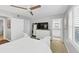 A well-lit bedroom features a ceiling fan, TV, and a glimpse into an attached bathroom at 2 Arpege Nw Way, Atlanta, GA 30327