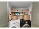 Organized laundry room with shelving, baskets, and side-by-side washer and dryer at 2 Arpege Nw Way, Atlanta, GA 30327