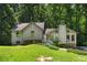 Charming two-story home with unique architectural details and a lush green lawn surrounded by mature trees at 3323 Silver Ridge Ct, Duluth, GA 30096