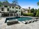 A stunning backyard boasts a luxurious pool with integrated lounge chairs, complemented by the home's charming exterior and lush greenery at 4225 Wieuca Ne Rd, Atlanta, GA 30342