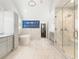 Spacious primary bathroom with marble tile, standalone tub, and glass shower at 4225 Wieuca Ne Rd, Atlanta, GA 30342