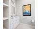 Bright bathroom with modern vanity, white cabinets, marble countertop, and decorative sailboat wall art at 4225 Wieuca Ne Rd, Atlanta, GA 30342
