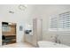 Bright bathroom features a soaking tub, shuttered window and marble accents at 4225 Wieuca Ne Rd, Atlanta, GA 30342