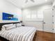 Cozy bedroom with hardwood floors, a gray striped bed, and natural light from windows with white shutters at 4225 Wieuca Ne Rd, Atlanta, GA 30342