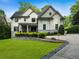 Stunning two-story white home featuring a well manicured lawn and stone retaining wall adding to the curb appeal at 4225 Wieuca Ne Rd, Atlanta, GA 30342