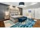 Bright main bedroom featuring a grey accent wall, high headboard, hardwood floors, and a blue rug at 4225 Wieuca Ne Rd, Atlanta, GA 30342