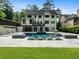 A private backyard oasis showcasing a pristine pool with integrated lounge areas and lush green surroundings at 4225 Wieuca Ne Rd, Atlanta, GA 30342