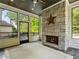 Inviting sunroom featuring a stone fireplace, wood ceiling, and large windows with a view of surrounding greenery at 4225 Wieuca Ne Rd, Atlanta, GA 30342