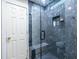 Modern shower with sleek marble tiling, glass enclosure, bench, and recessed shelf, combining luxury with functionality at 4850 Lake Fjord Pass, Marietta, GA 30068