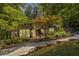 Exterior view of a home with beautiful landscaping, mature trees, and a winding driveway at 4850 Lake Fjord Pass, Marietta, GA 30068