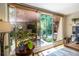 Bright office features large windows overlooking a lush backyard, complemented by a distinctive wooden desk and natural light at 4850 Lake Fjord Pass, Marietta, GA 30068