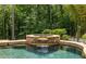 Inviting in-ground pool with a charming stone waterfall feature, nestled among lush landscaping for a serene backyard escape at 4850 Lake Fjord Pass, Marietta, GA 30068
