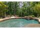 Secluded backyard pool and spa with waterfall feature and surrounding deck, offering a peaceful retreat in nature at 4850 Lake Fjord Pass, Marietta, GA 30068