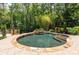 Beautiful in-ground pool with a stone waterfall feature surrounded by lush landscaping, offering a private backyard oasis at 4850 Lake Fjord Pass, Marietta, GA 30068