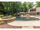 Beautifully designed pool with stone accents and spa, complemented by an outdoor kitchen and lounge area for upscale entertaining at 4850 Lake Fjord Pass, Marietta, GA 30068