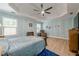 Bright main bedroom featuring fan, blue accent wall, and two large windows at 549 Greenridge Ln, Loganville, GA 30052