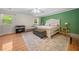 Spacious main bedroom with ample natural light, hardwood floors, and a soft green accent wall for a relaxing ambiance at 1438 Heritage Glen Dr, Marietta, GA 30068