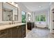 Bright bathroom featuring double vanities, freestanding tub, modern fixtures, and stylish flooring at 2179 William Way, Atlanta, GA 30345