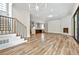 A bright open living room with fireplace, stairs, and view of modern kitchen with island at 2179 William Way, Atlanta, GA 30345