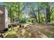 Expansive backyard featuring mature trees, a wooden deck, storage shed and space for outdoor activities at 2935 Sawgrass Sw Trl, Lilburn, GA 30047