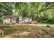 Large backyard view of the home featuring a wooden deck, mature trees, and ample space for outdoor living at 2935 Sawgrass Sw Trl, Lilburn, GA 30047