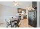 The kitchen and dining area features black cabinets, neutral countertops and flooring, blending function with style at 2935 Sawgrass Sw Trl, Lilburn, GA 30047