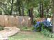Serene backyard with a wooden fence, blue hydrangeas, and a gravel area for outdoor enjoyment at 49 Brinkley Ct, Dallas, GA 30157