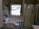 Bright bathroom showcasing a luxurious soaking tub with tiled surround and a separate glass-enclosed shower at 49 Brinkley Ct, Dallas, GA 30157