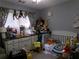 bedroom filled with toys and natural light, featuring an organized dresser and crib at 49 Brinkley Ct, Dallas, GA 30157