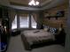 Cozy main bedroom features tray ceiling, plush carpet, wood accent wall, and comfortable furnishings at 49 Brinkley Ct, Dallas, GA 30157