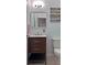 Stylish half bathroom with modern vanity, neutral paint, and decorative mirror at 440 Berckman Nw Dr, Lilburn, GA 30047