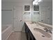 Bathroom featuring double vanity with white sinks and dark cabinets, bathtub, and toilet at 440 Berckman Nw Dr, Lilburn, GA 30047